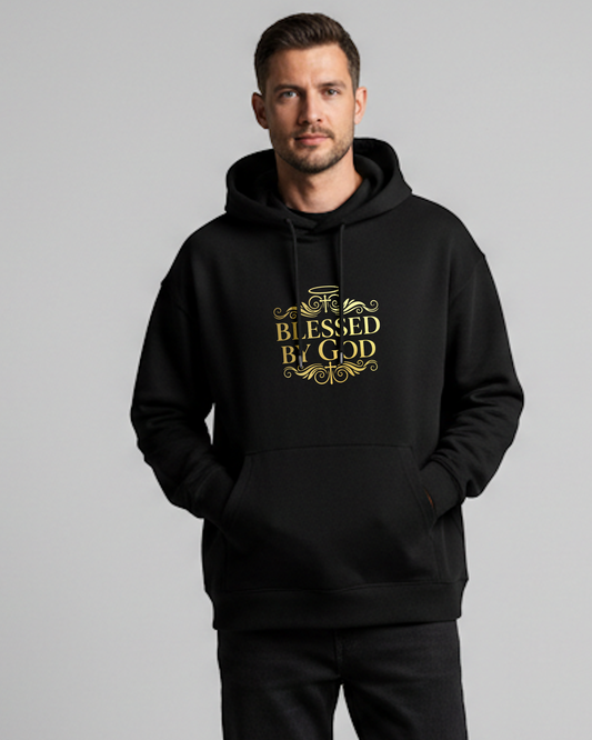 Man wearing a black hoodie with 'Blessed by God' gold text on a gray background