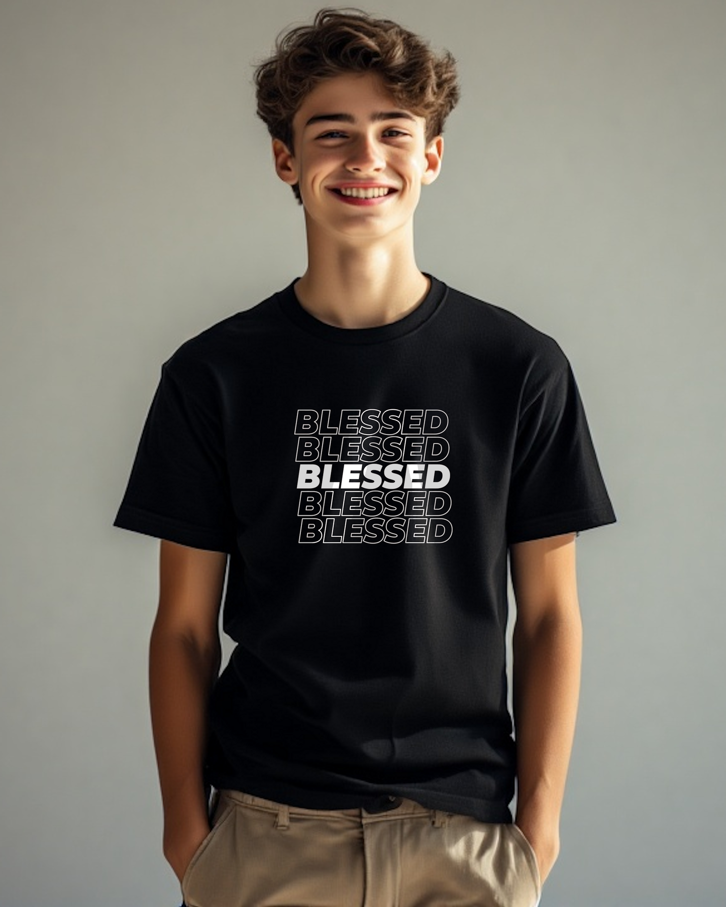 A young man outside wearing a black t-shirt with multiple lines of "Blessed" text printed on the front.