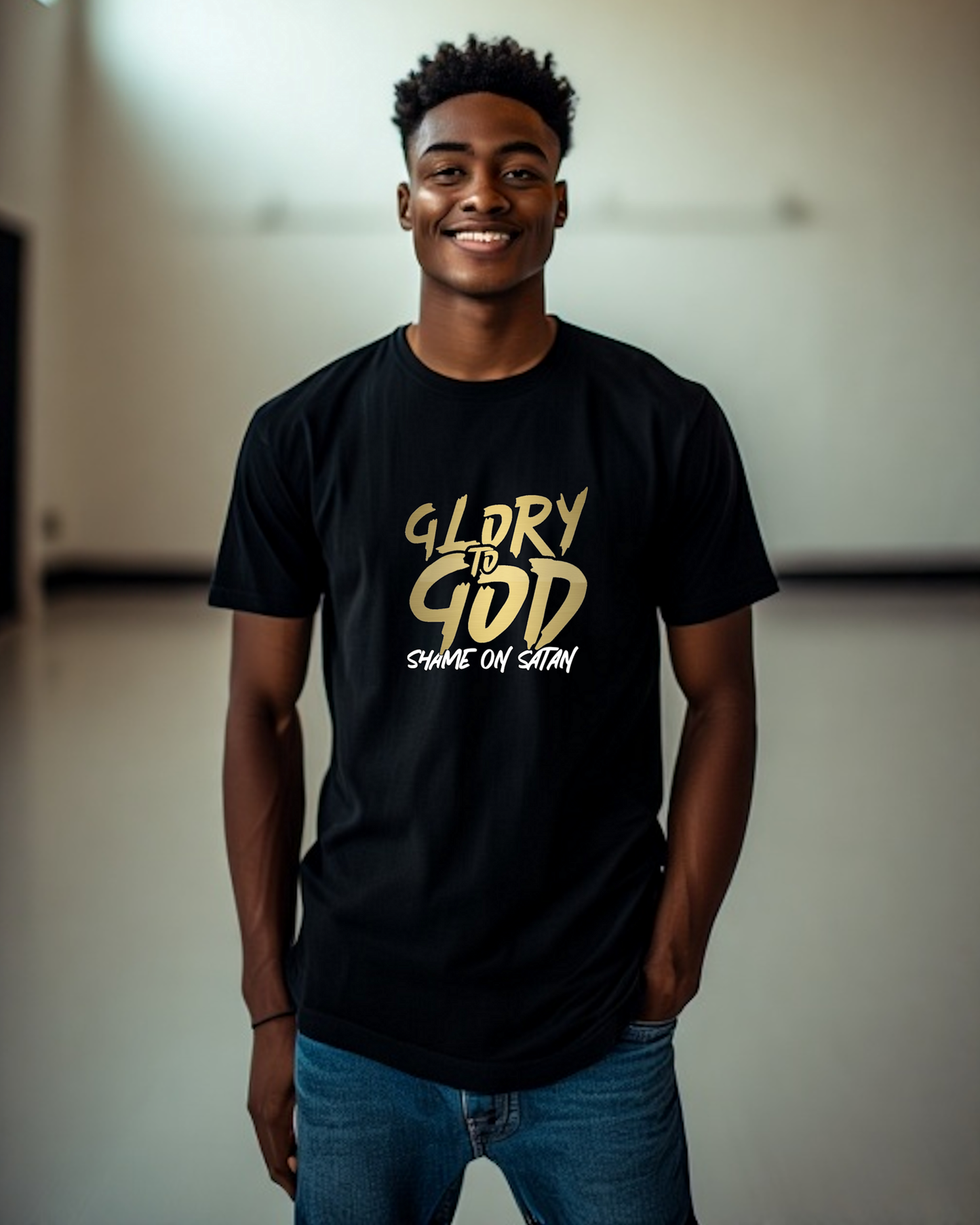 A man wearing a black t-shirt with a gold Heavenly Dreamwear "Glory to God" logo printed on the front, with a white statement "shame on satan"
