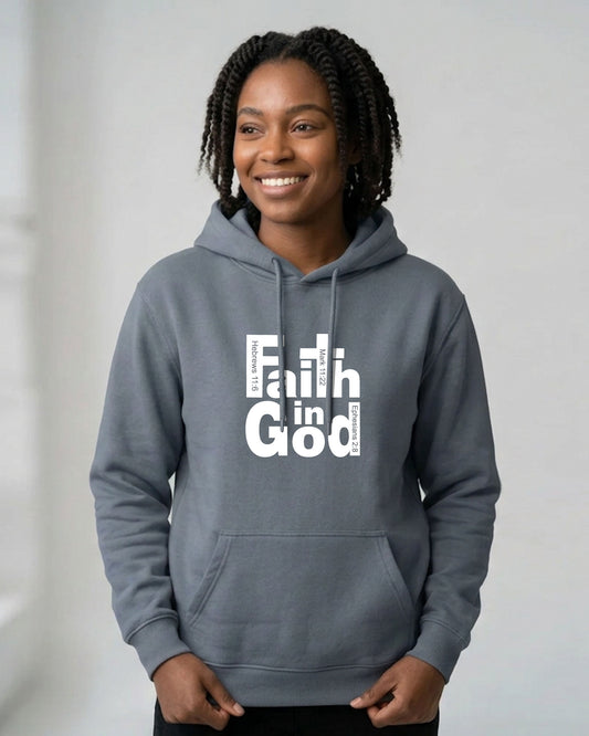 A smiling woman with braided hair wearing a heather gray pullover hoodie with a white graphic text print reading 'Faith in God' on the chest, standing against a light gray background.