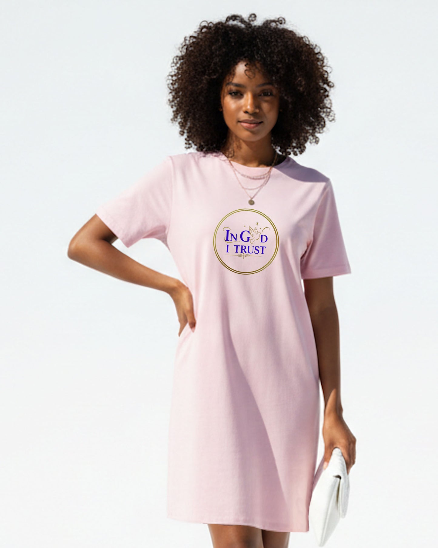 Woman wearing a pink Heavenly Dreamwear t-shirt dress with a logo bearing text, "In God I trust" on a white background.