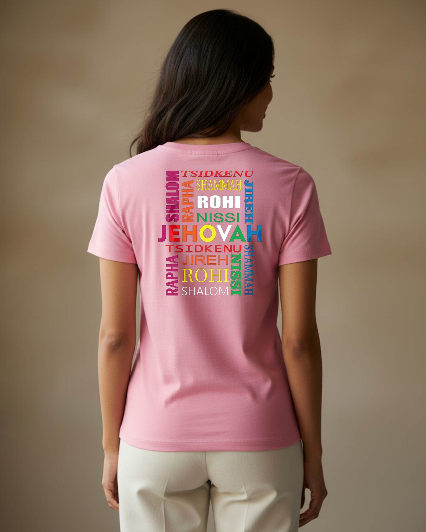 Woman wearing a pink t-shirt with colorful Hebrew text against a plain beige background