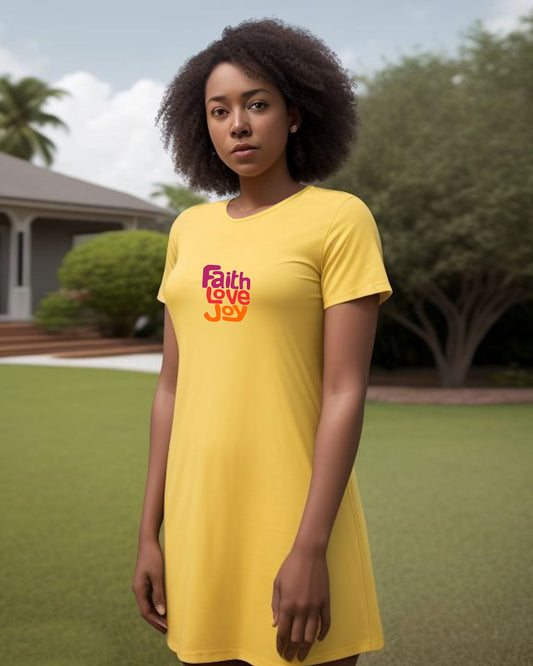 Woman wearing a yellow t-shirt dress with 'Faith Love Joy' text outdoors.