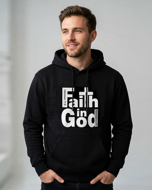 A man wearing a black pullover hoodie with a large white graphic print that reads 'Faith in God' with Bible verse references, posed inside a light gray walled room