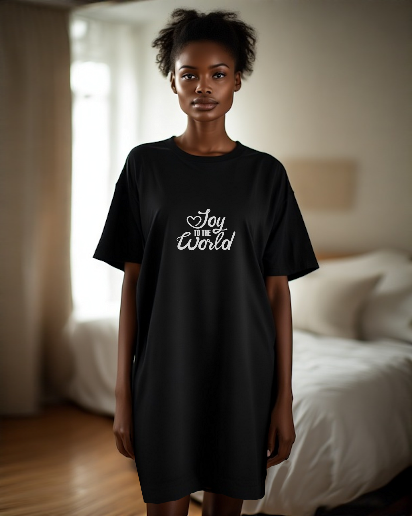 Woman wearing a black t-shirt with white text, "Joy to the World", in a bedroom setting