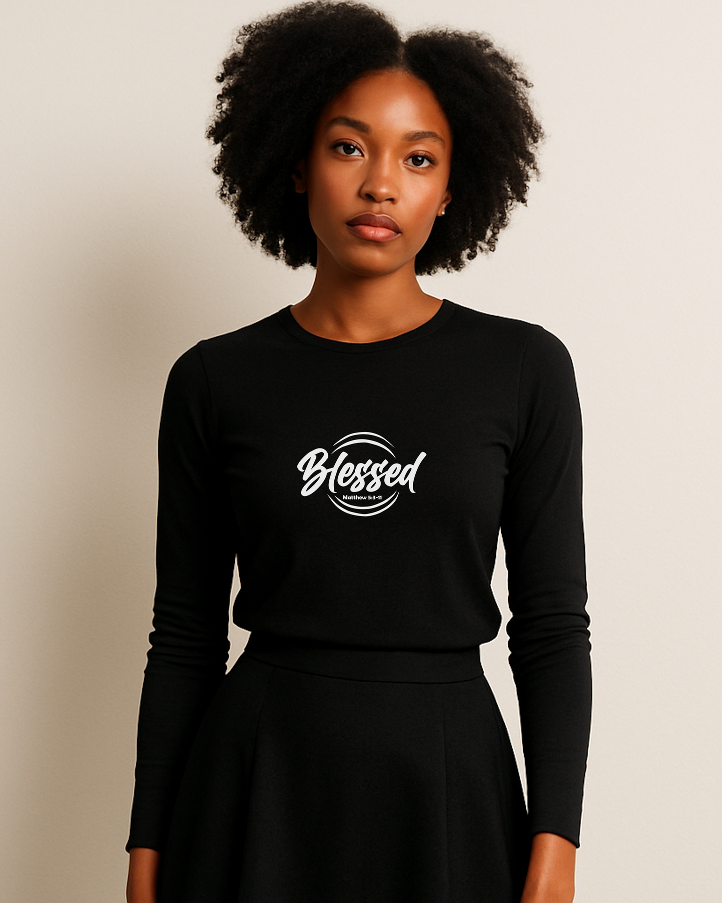 Woman wearing a black long-sleeve shirt with white 'Blessed' text on a beige background
