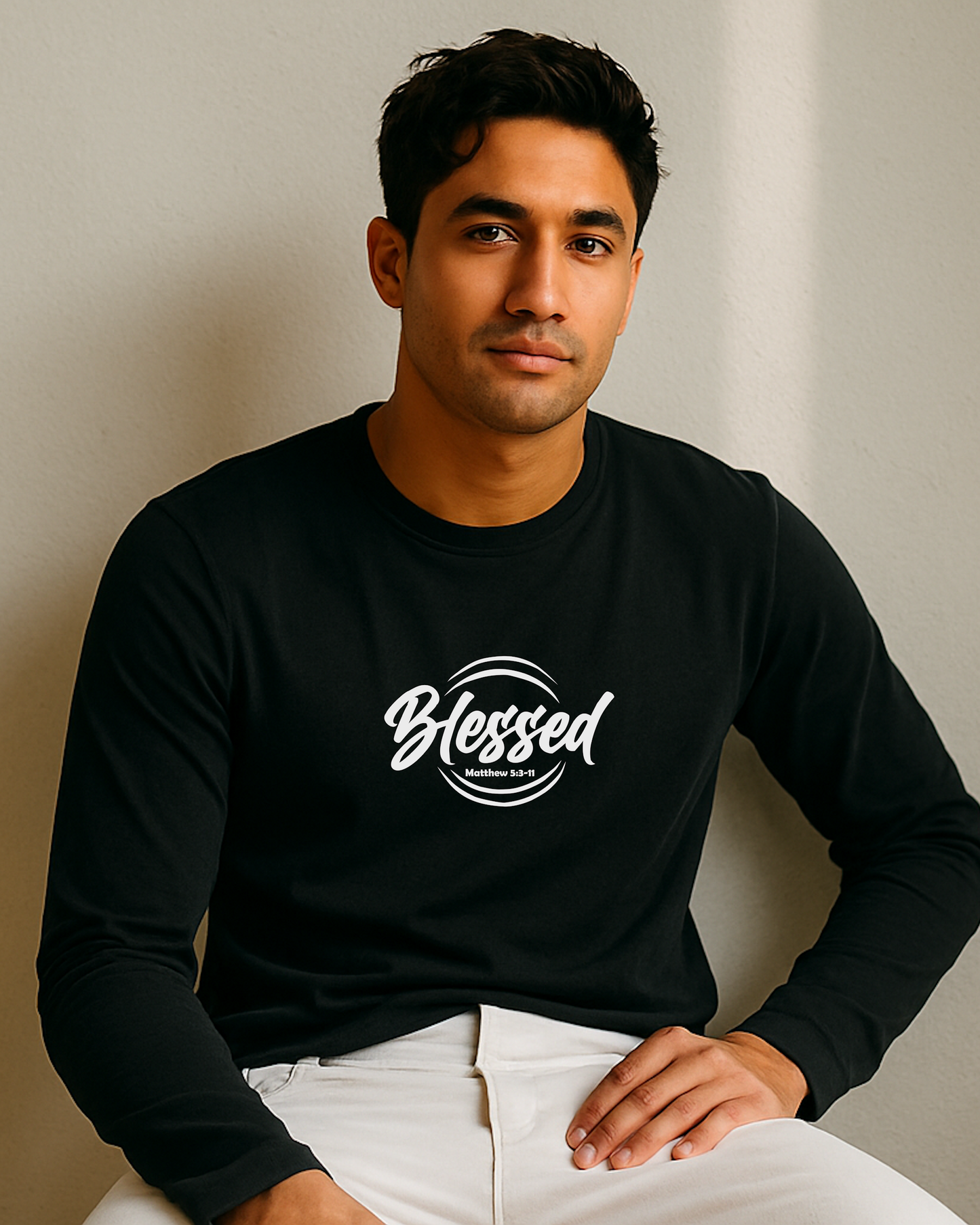 Man wearing a black long-sleeve shirt with 'Blessed' white text against a plain background
