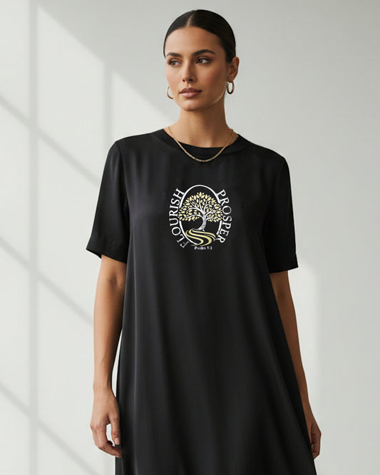 Woman wearing a black t-shirt with a silver/gold logo on a white background