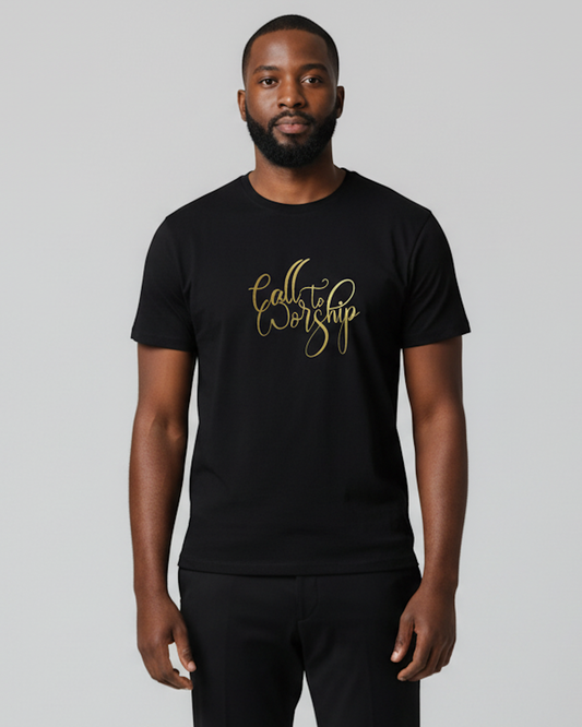 A man wearing a black crewneck t-shirt with 'Call to Worship' printed in gold cursive script on the chest, photographed against a solid gray background.