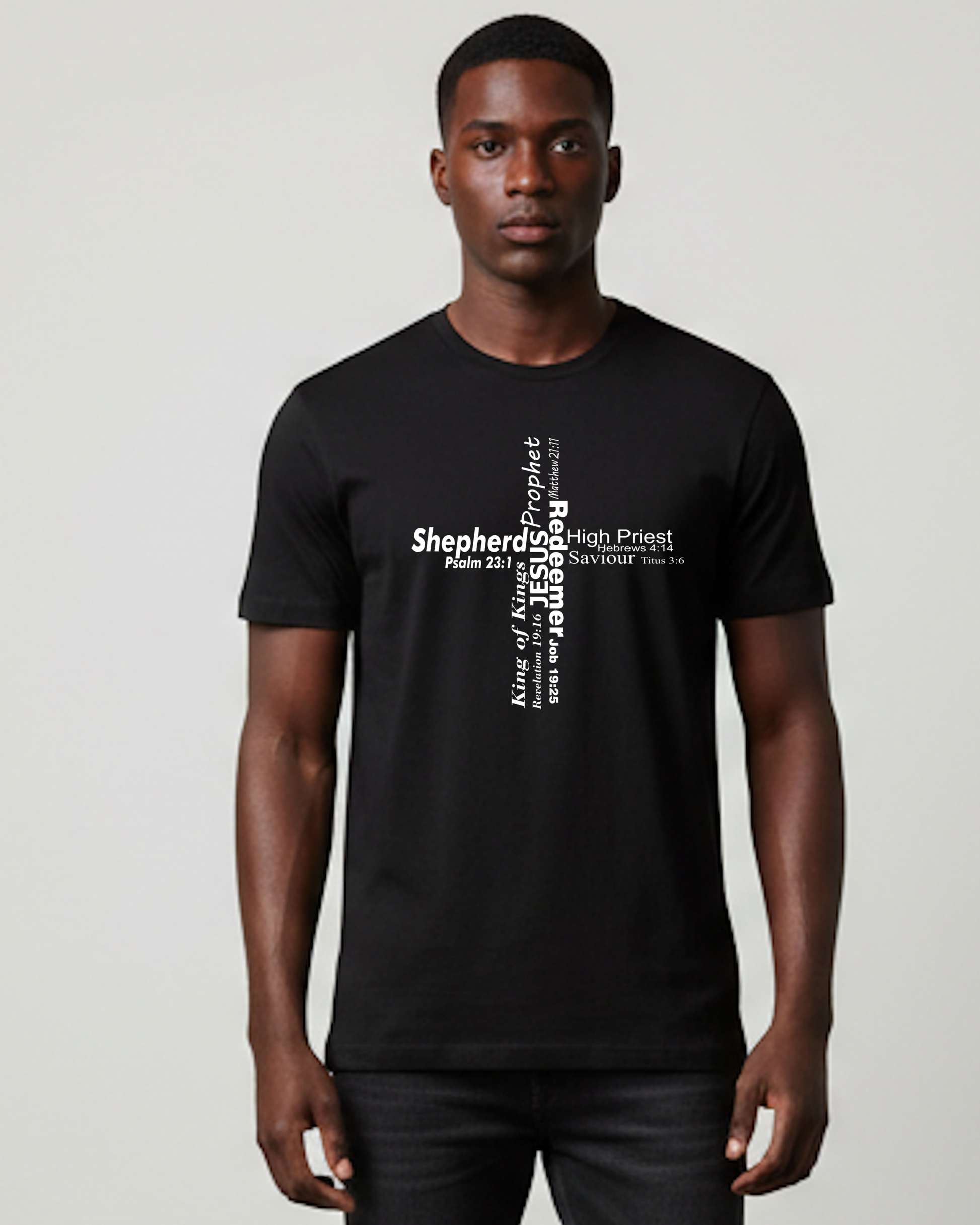 A man wearing a black short-sleeve t-shirt with a white typographic cross graphic made from words stating the roles of Jesus on the chest, standing against a light gray studio background.
