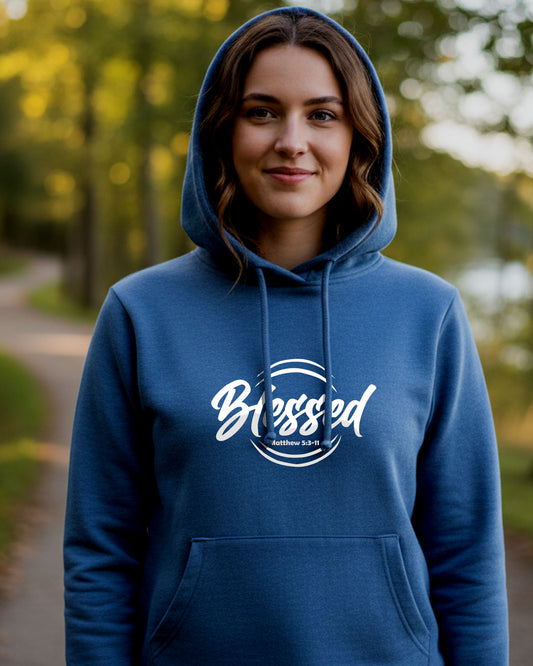 A young woman in a park wearing a blue hoodie with a text logo that says "Blessed"