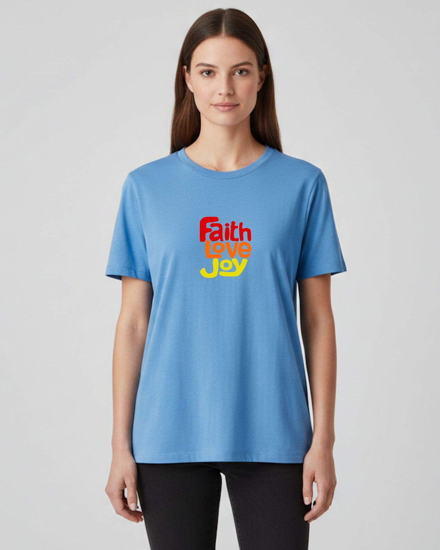 Woman wearing a blue t-shirt with red, orange and yellow 'Faith Love Joy' text on a plain background