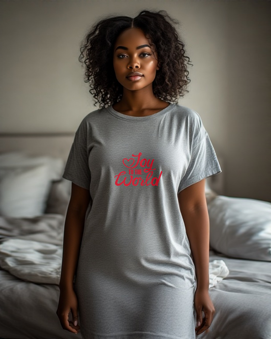 Woman wearing a gray t-shirt with red text, "Joy to the World", in a bedroom setting