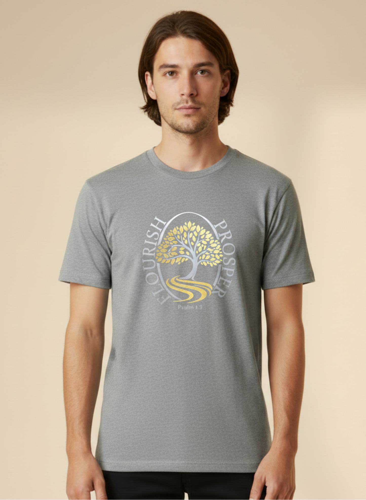 A man wearing a grey short-sleeve t-shirt wit a silver and gold logo against a beige background
