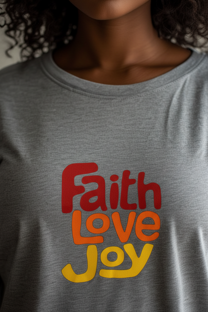 Closeup of neck of a grey t-shirt dress with a 'Faith Love Joy' text logo in red, orange, and yellow worn by a woman. 
