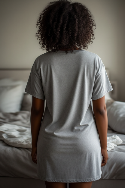 Rear view of a woman wearing a grey nightdress in a bedroom.