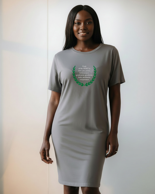Woman wearing a gray t-shirt dress with a green laurel design around white text on a plain background