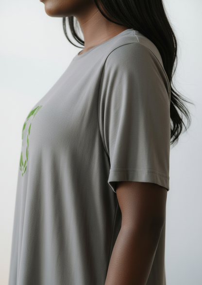 Closeup of sleeve of grey t-shirt dress worn by a woman on a plain background