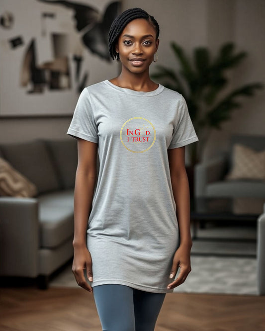 Woman wearing a gray t-shirt with a "In God I trust" text surrounded by a gold ring logo in a living room setting