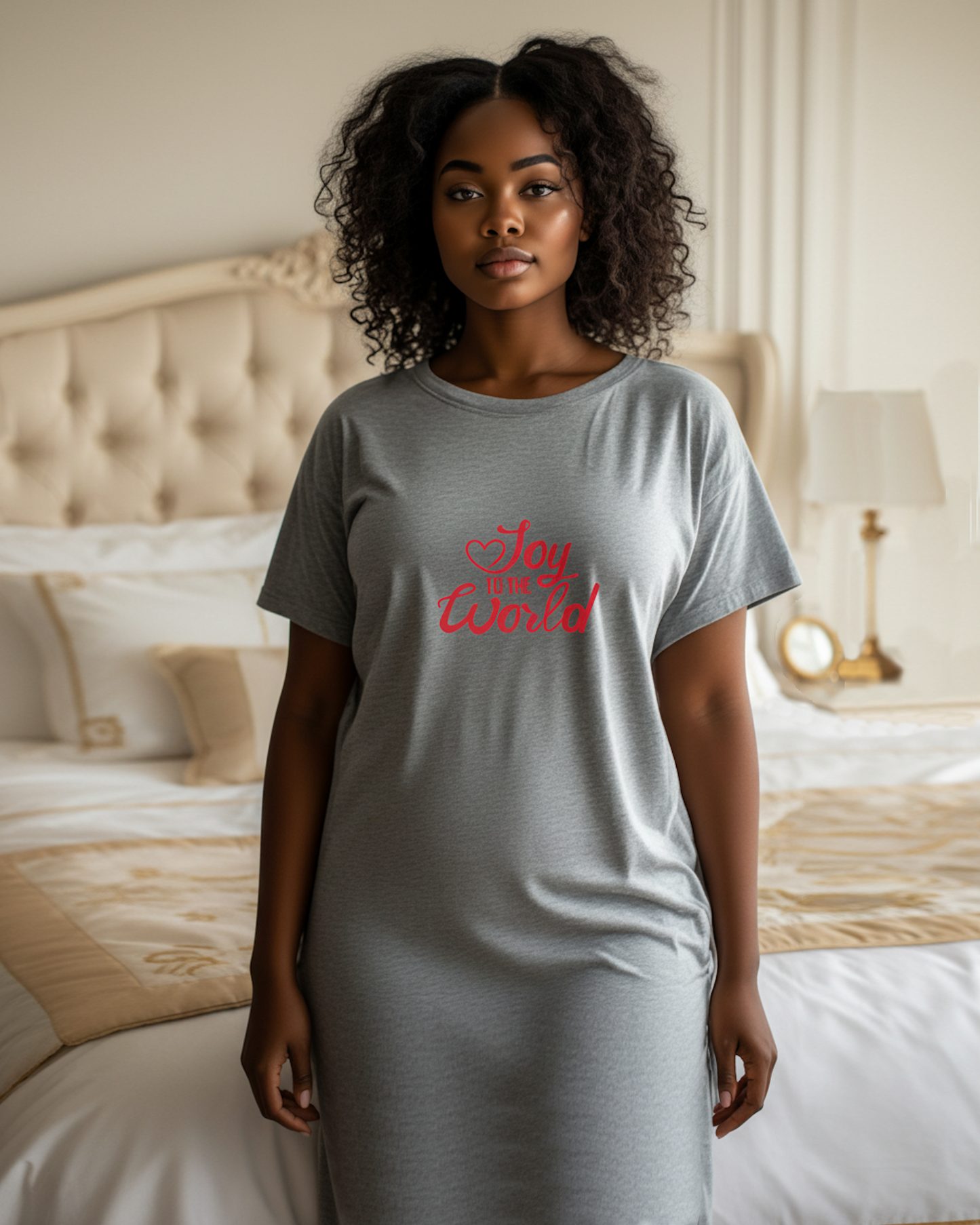 Woman wearing a gray t-shirt with red text, "Joy to the World", in a bedroom setting