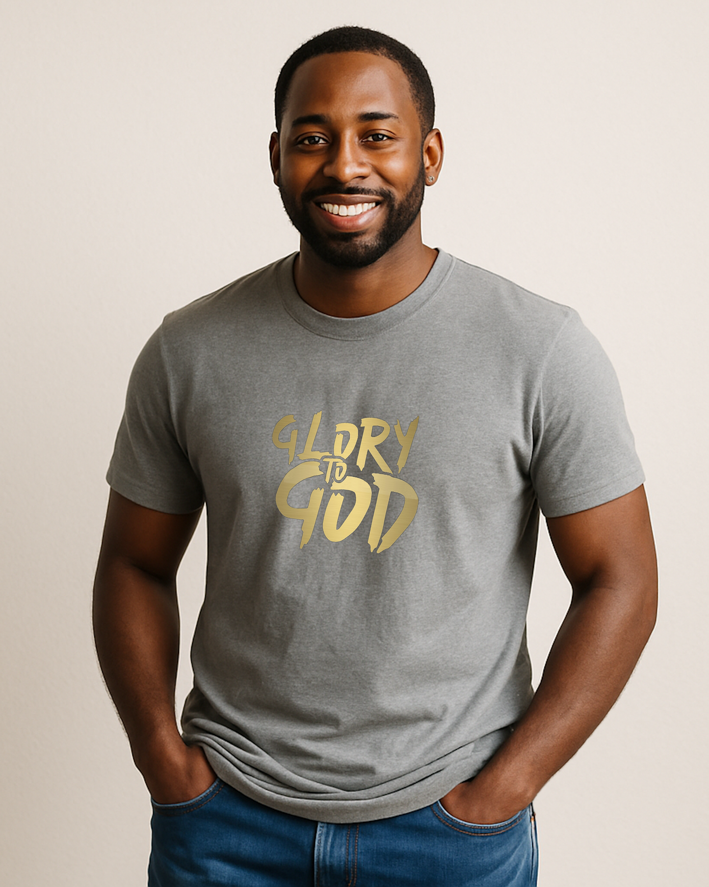 A man wearing a grey t-shirt with a Heavenly Dreamwear "Glory to God" logo printed in gold on the front.