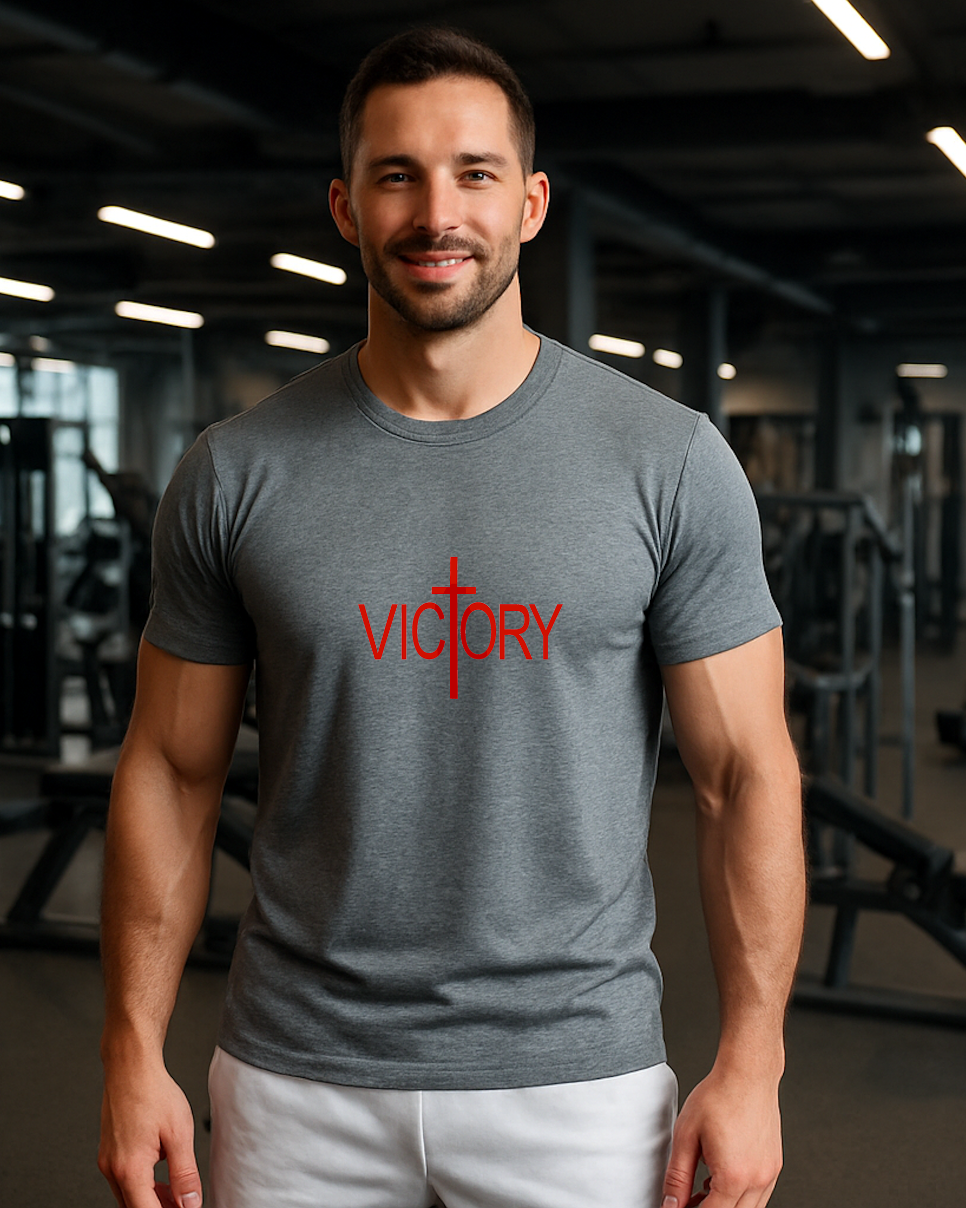Man wearing a gray short sleeve T-shirt with 'VICTORY' printed in red inside a gym.