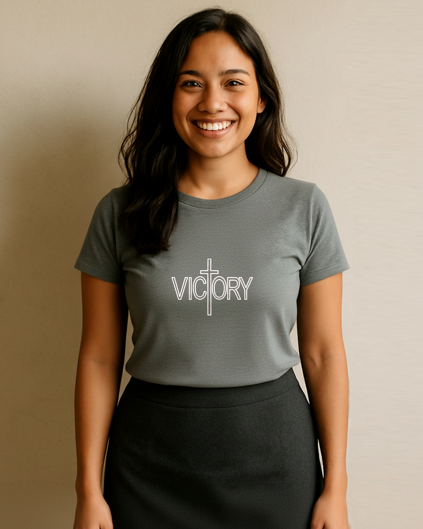 Woman wearing a gray t-shirt with 'VICTORY' printed on it against a beige background