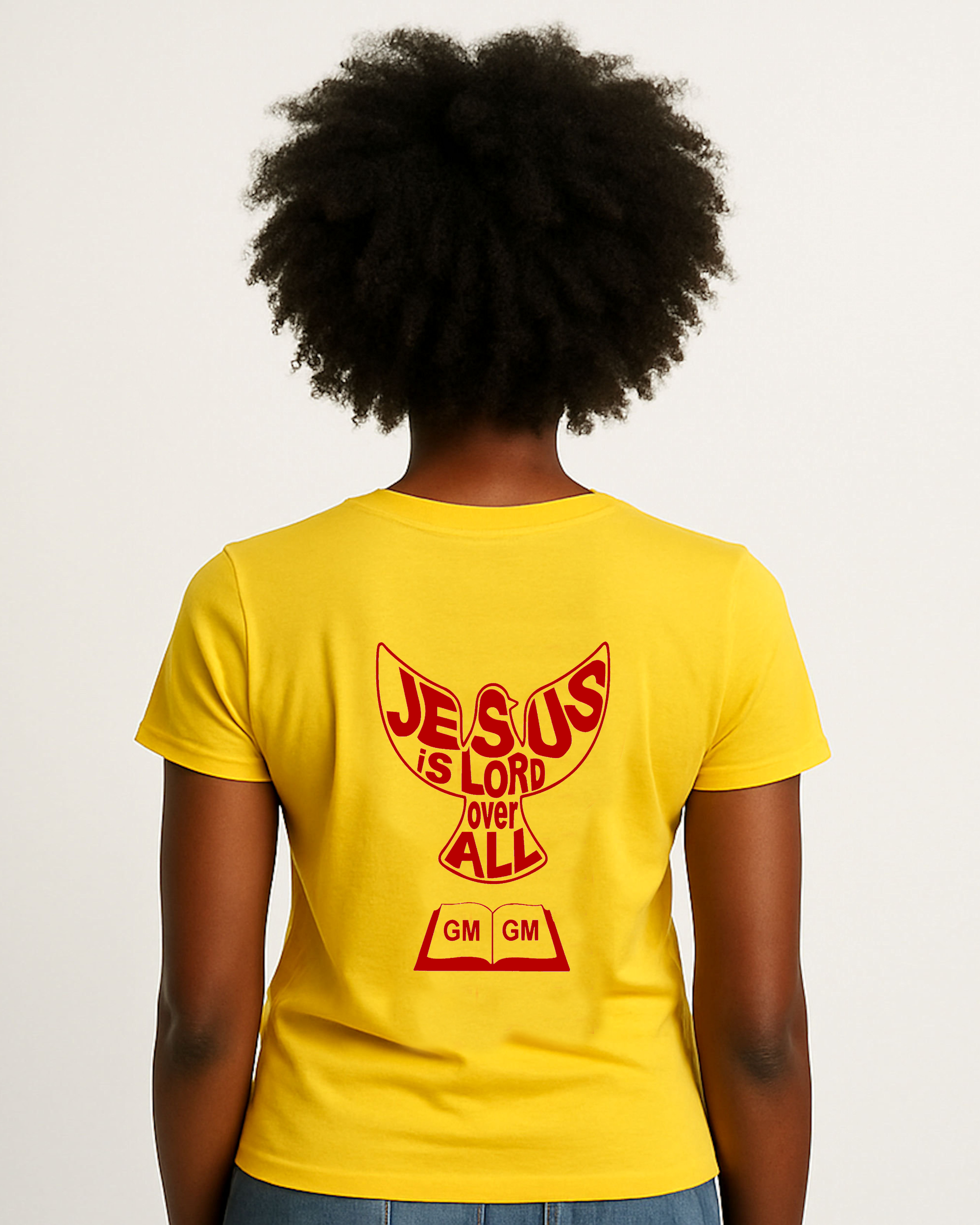 A woman wearing a yellow t-shirt with 'Jesus is Lord Over All' text on the back, standing against a plain background.