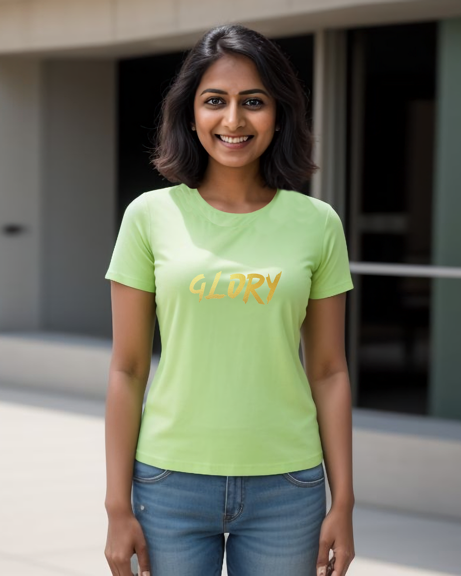 A woman wearing a lime green t-shirt with a gold "Glory" text logo printed on the front.