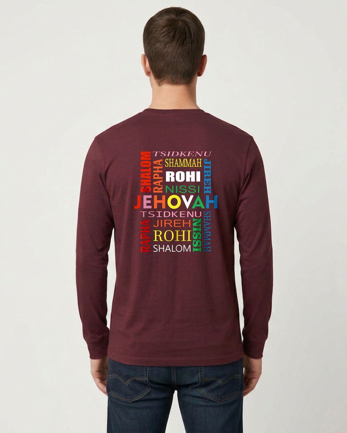 A man viewed from behind wearing a maroon long-sleeve t-shirt with a colorful Hebrew text graphic on the back, paired with dark blue jeans, against a light gray background.