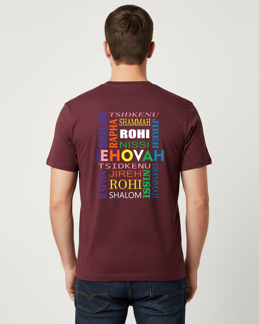 A man viewed from behind wearing a maroon short-sleeve t-shirt with a colorful text graphic on the back, paired with dark blue jeans, against a light gray studio background.