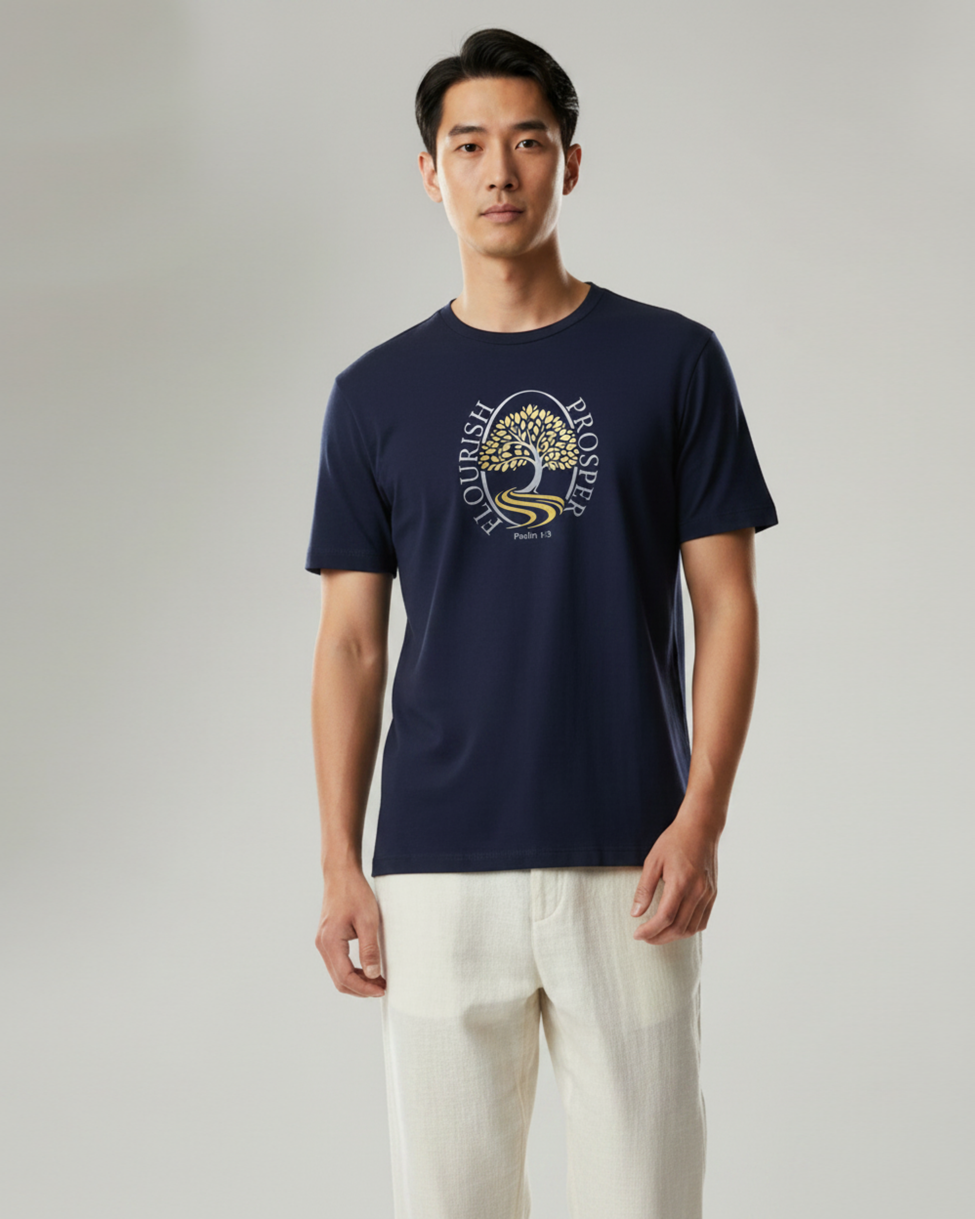 A man wearing a navy blue short-sleeve t-shirt wit a silver and gold logo against a white background