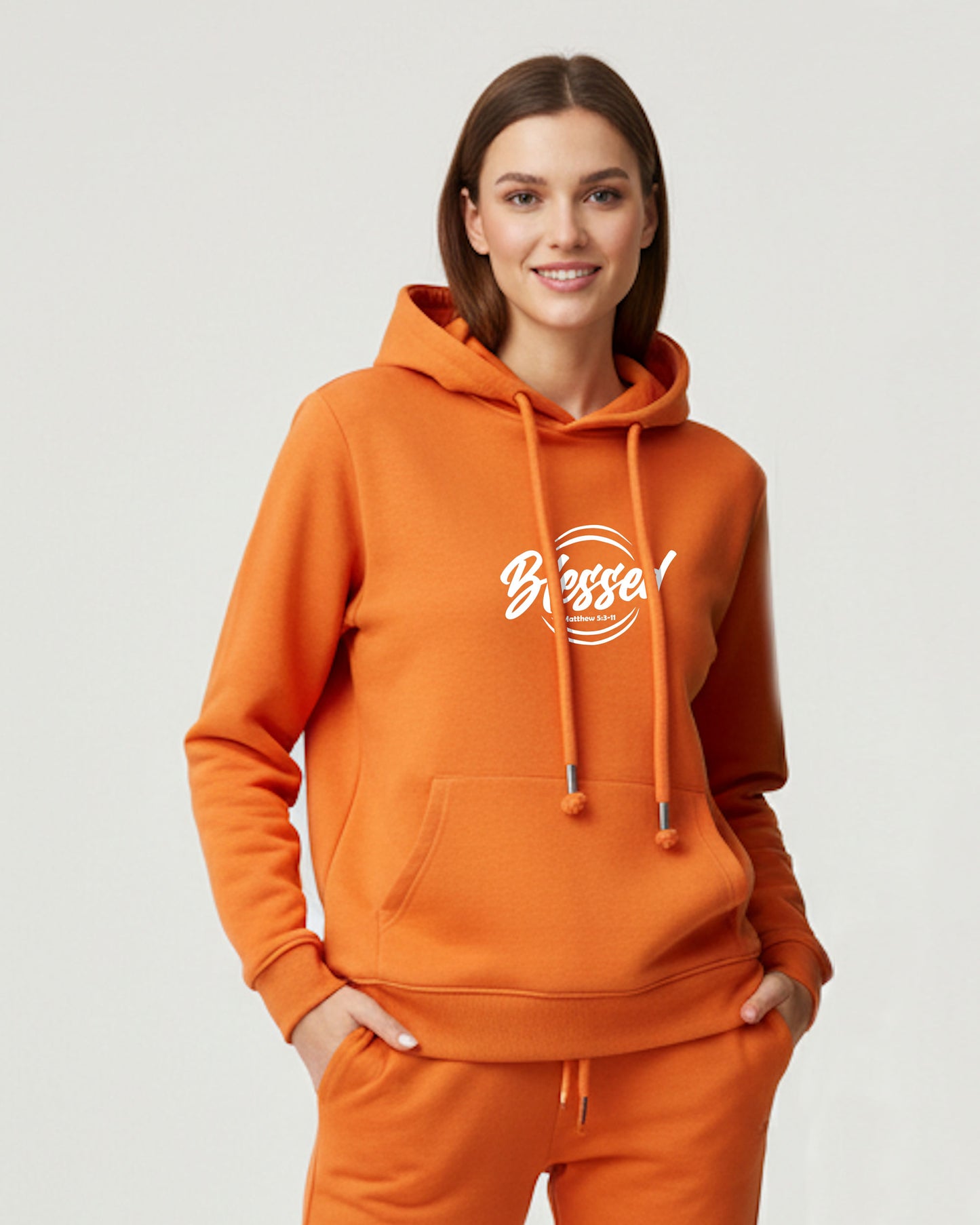 Woman wearing an orange hoodie with 'Blessed' text on a light gray background