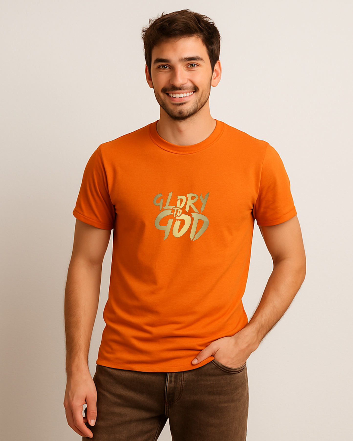 A man standing wearing an orange t-shirt with a Heavenly Dreamwear "Glory to God" logo printed in gold on the front.