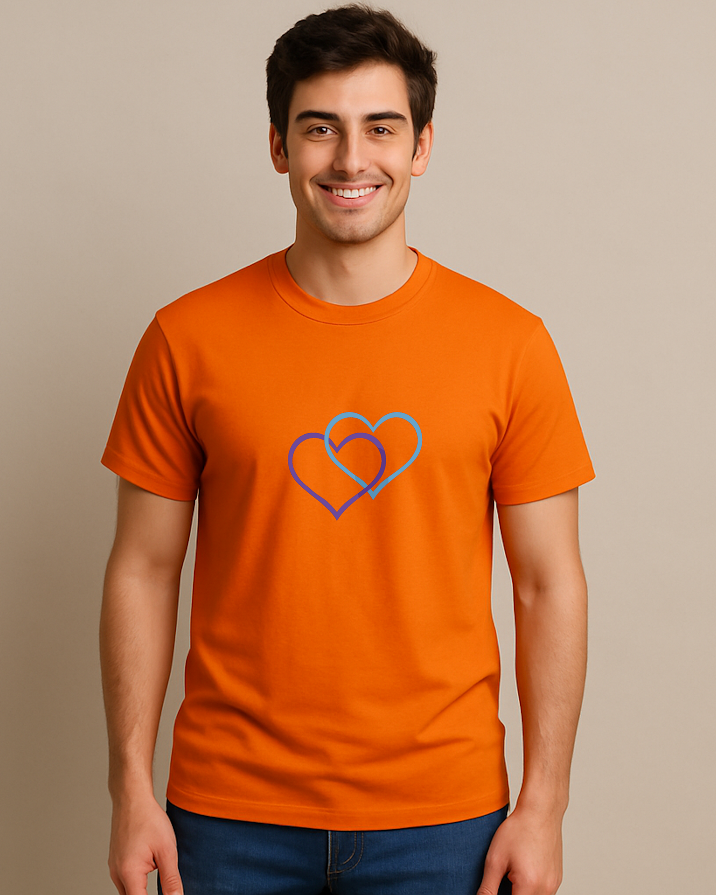 A man wearing an orange t-shirt with a Heavenly Dreamwear logo comprised of a purple and blue inter-twinned hearts.