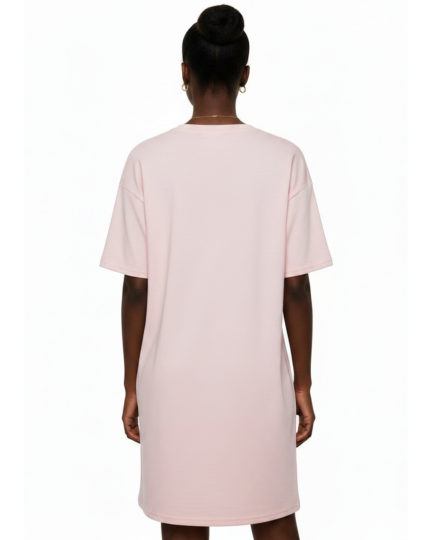 Woman wearing a light pink t-shirt dress against a white background