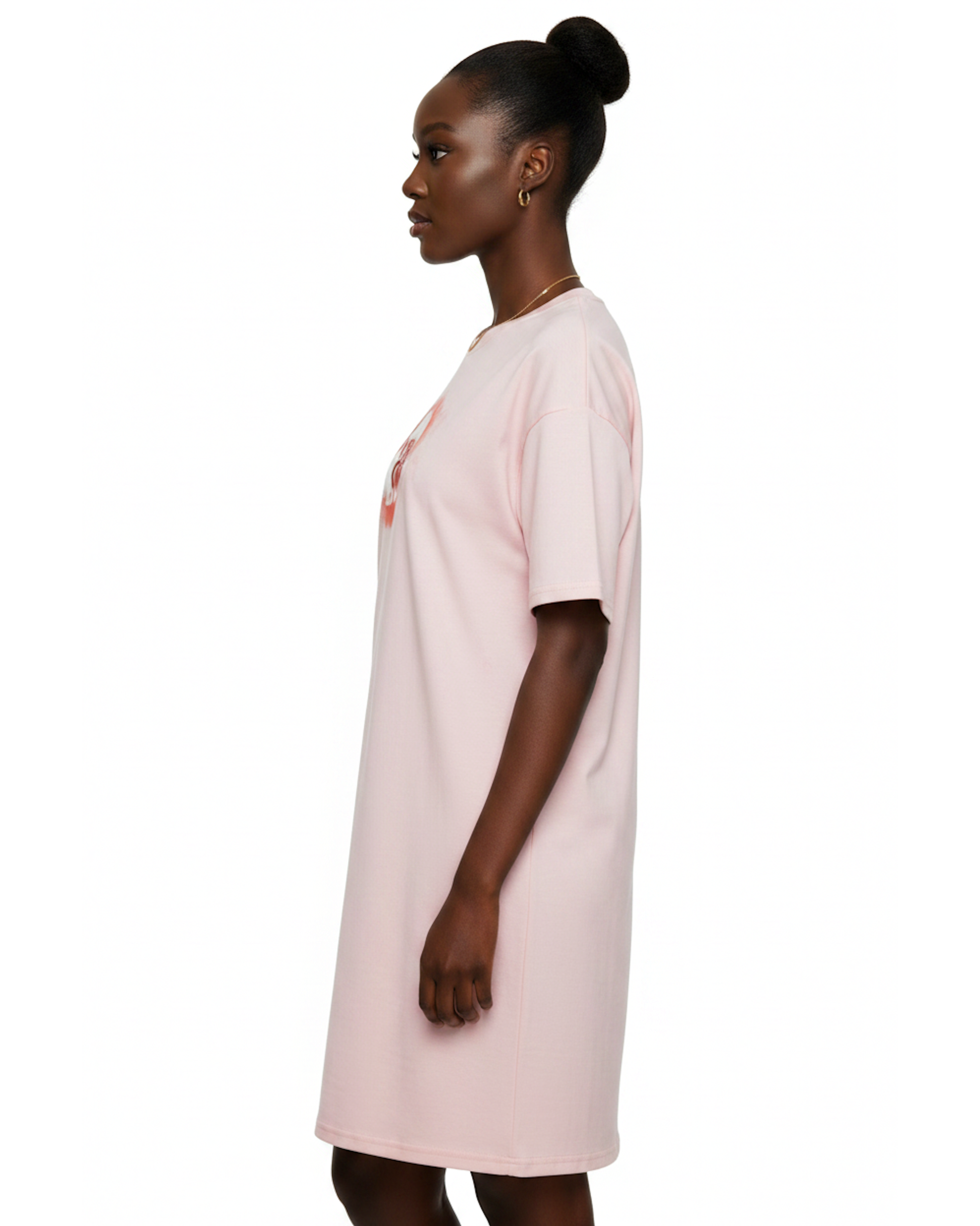 Woman wearing a light pink t-shirt dress with a graphic cloud logo printed on front against a white background