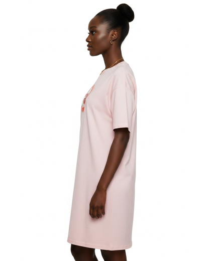 Woman wearing a light pink t-shirt dress with a graphic cloud logo printed on front against a white background