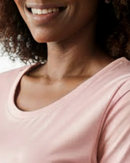 Closeup of the neck area of a light pink t-shirt dress worn by a woman