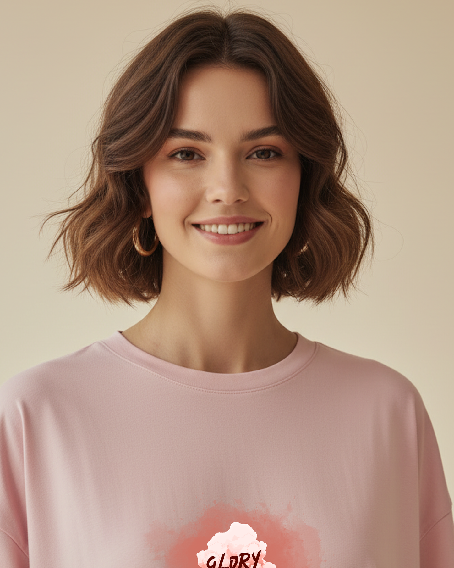 A closeup top front view of a woman wearing a pink t-shirt dress with a graphic Glory to God text in a cloud design in a bright sunlit room.