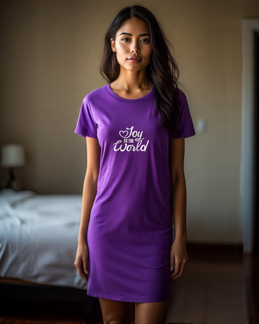 Woman wearing a purple t-shirt with white text, "Joy to the World", in a bedroom setting
