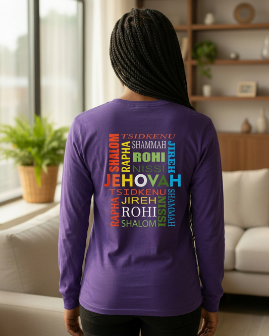 A woman viewed from behind wearing a purple long-sleeve shirt with colorful text on the back reading 'Jehovah' surrounded by religious words, in a bright living room.