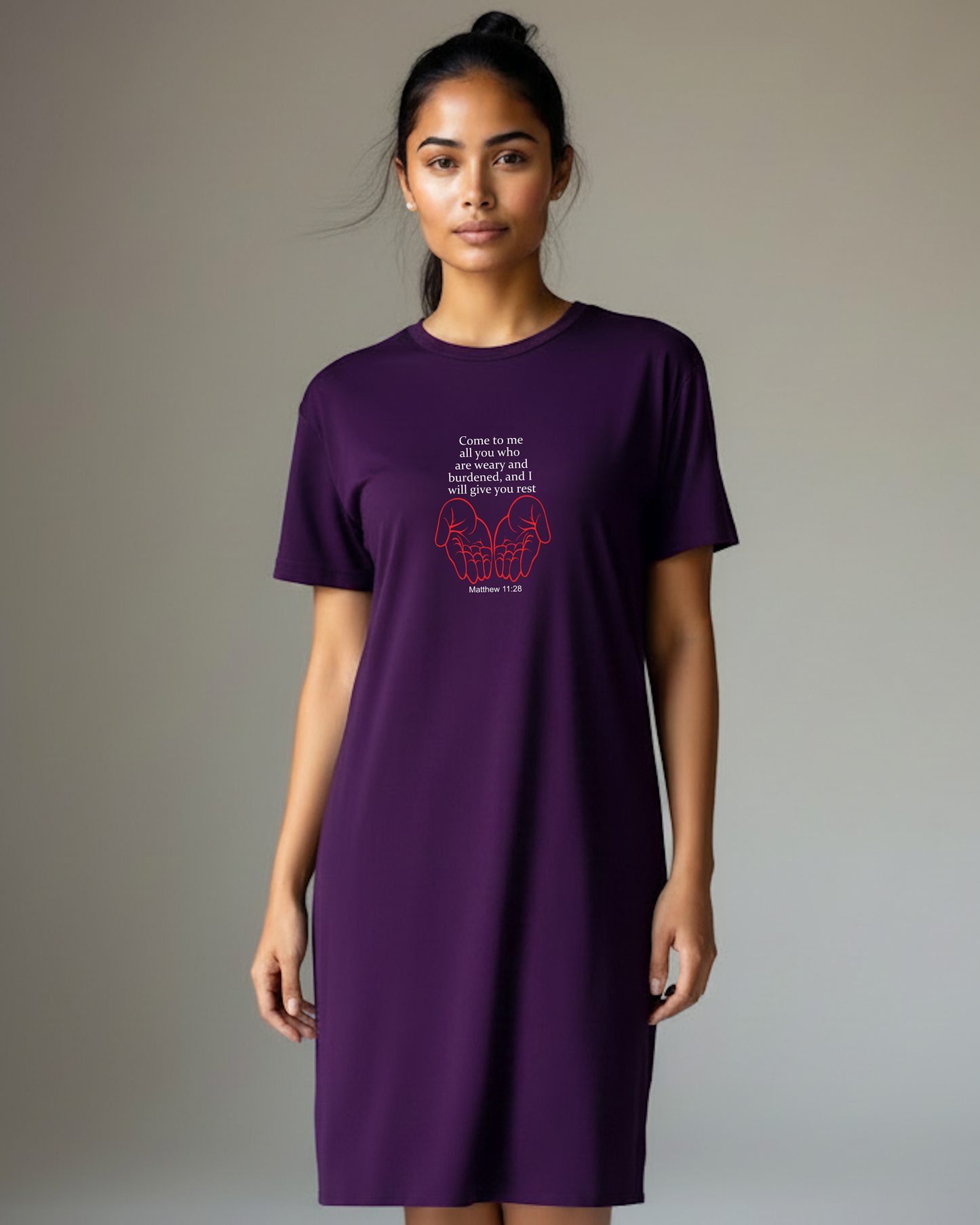 A woman wearing a purple short-sleeve t-shirt dress with a white quote and red graphic on the chest, set against a plain background.