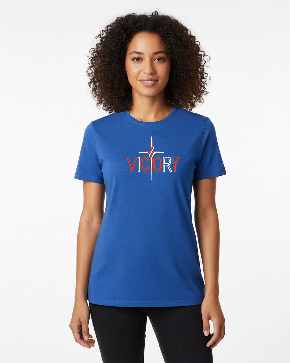 A woman with curly dark hair wearing a royal blue short-sleeve t-shirt with a red and white 'VICTORY' graphic on the chest, paired with black leggings, against a plain white studio background.