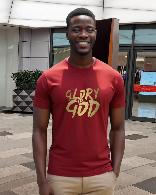 A man standing in a shopping mall wearing a red t-shirt with a Heavenly Dreamwear "Glory to God" logo printed in gold on the front.