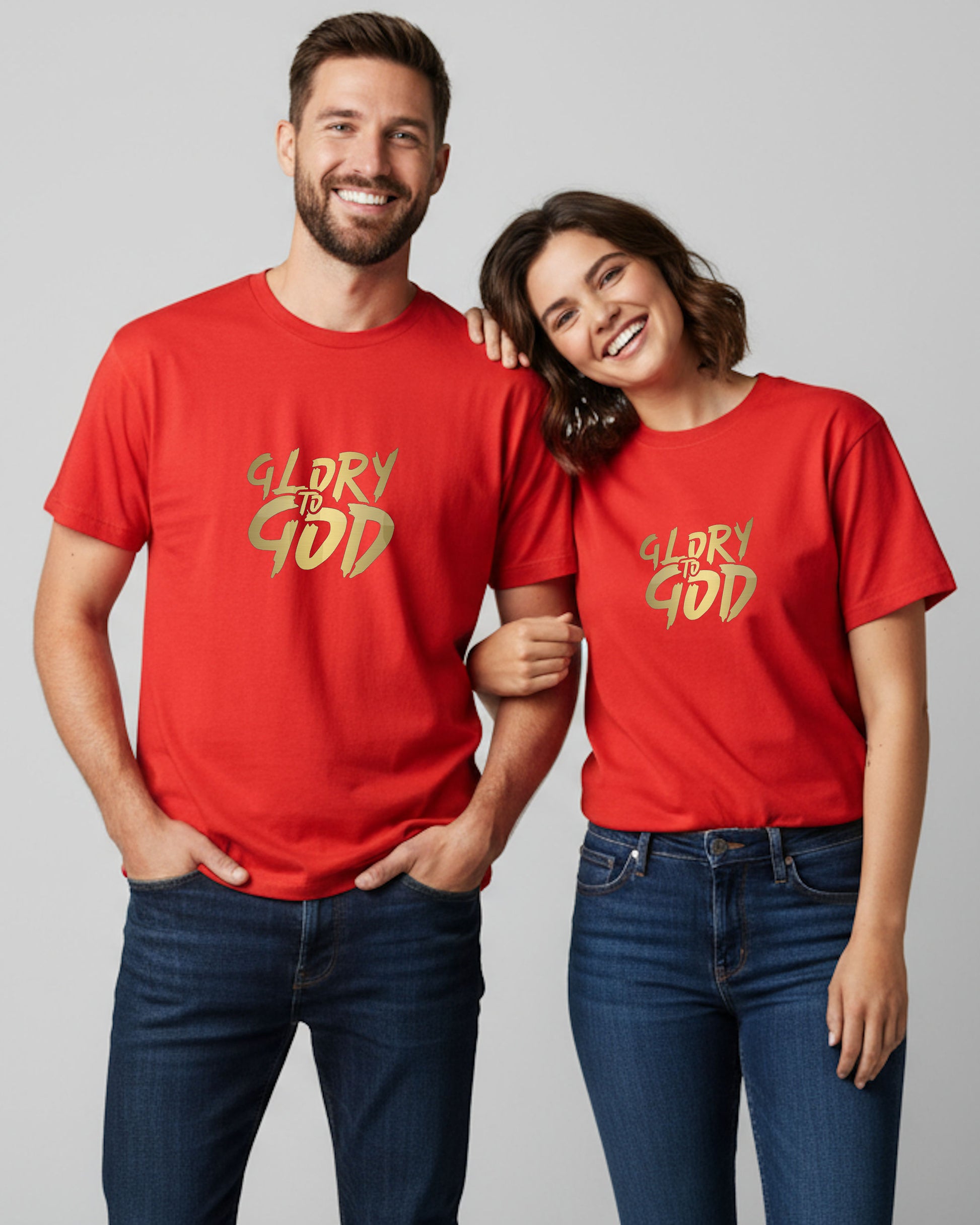 A man and woman wearing red t-shirts with gold 'Glory to God' text on a plain background