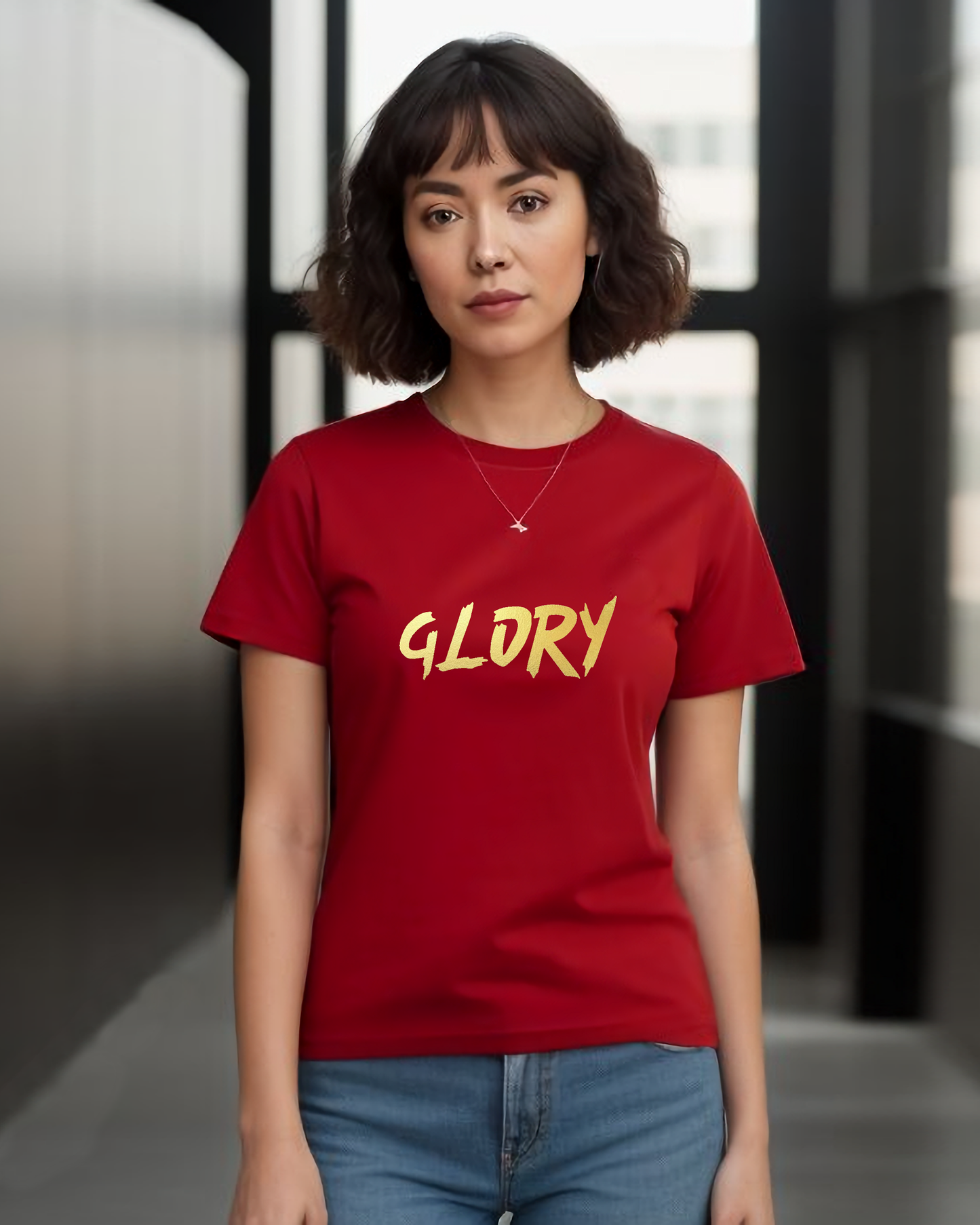 A woman wearing a red t-shirt with a gold "Glory" text logo printed on the front.