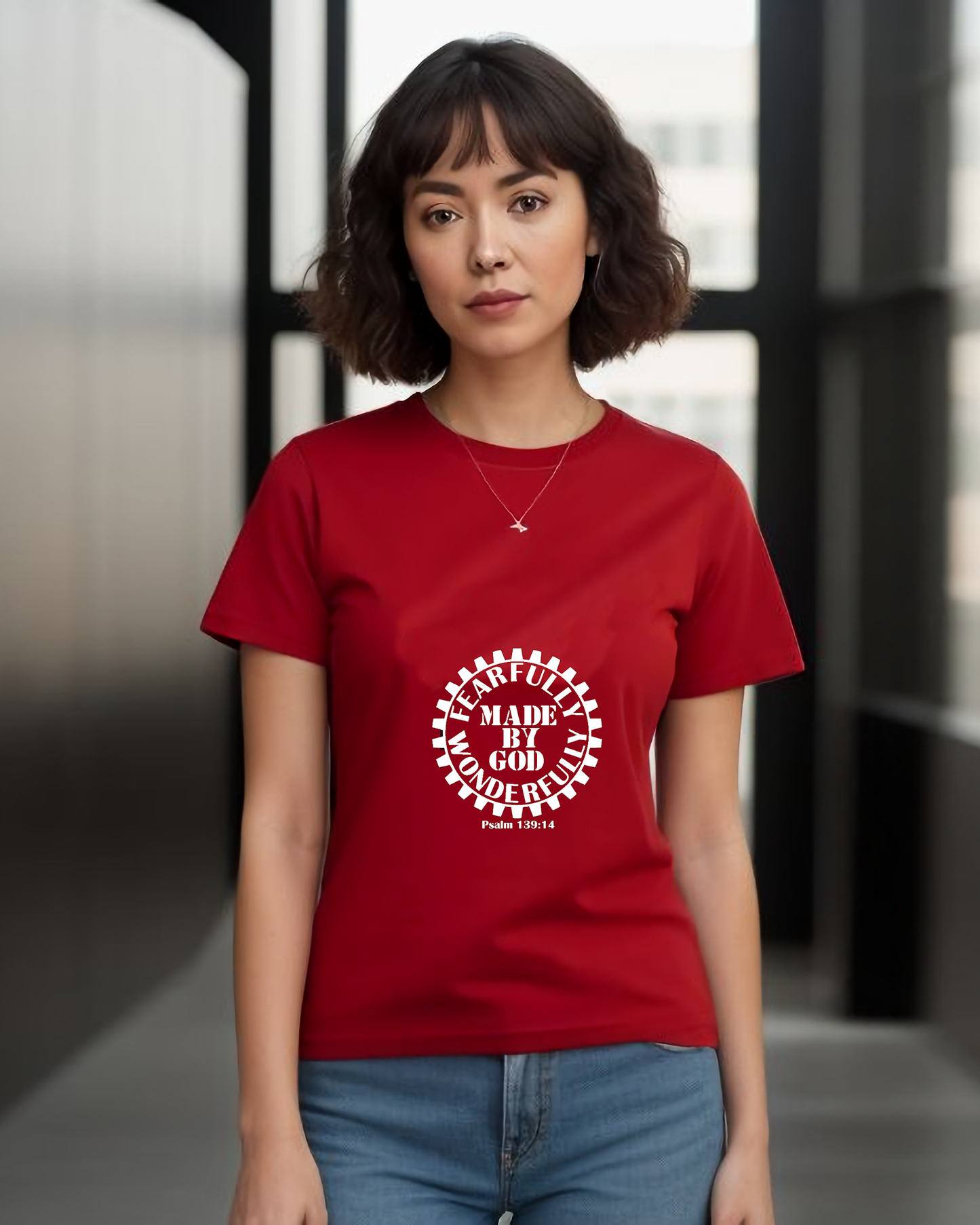 A woman wearing a red t-shirt with a white Heavenly Dreamwear logo with the text "Fearfully Wonderfully Made by God" inside a geared wheel.