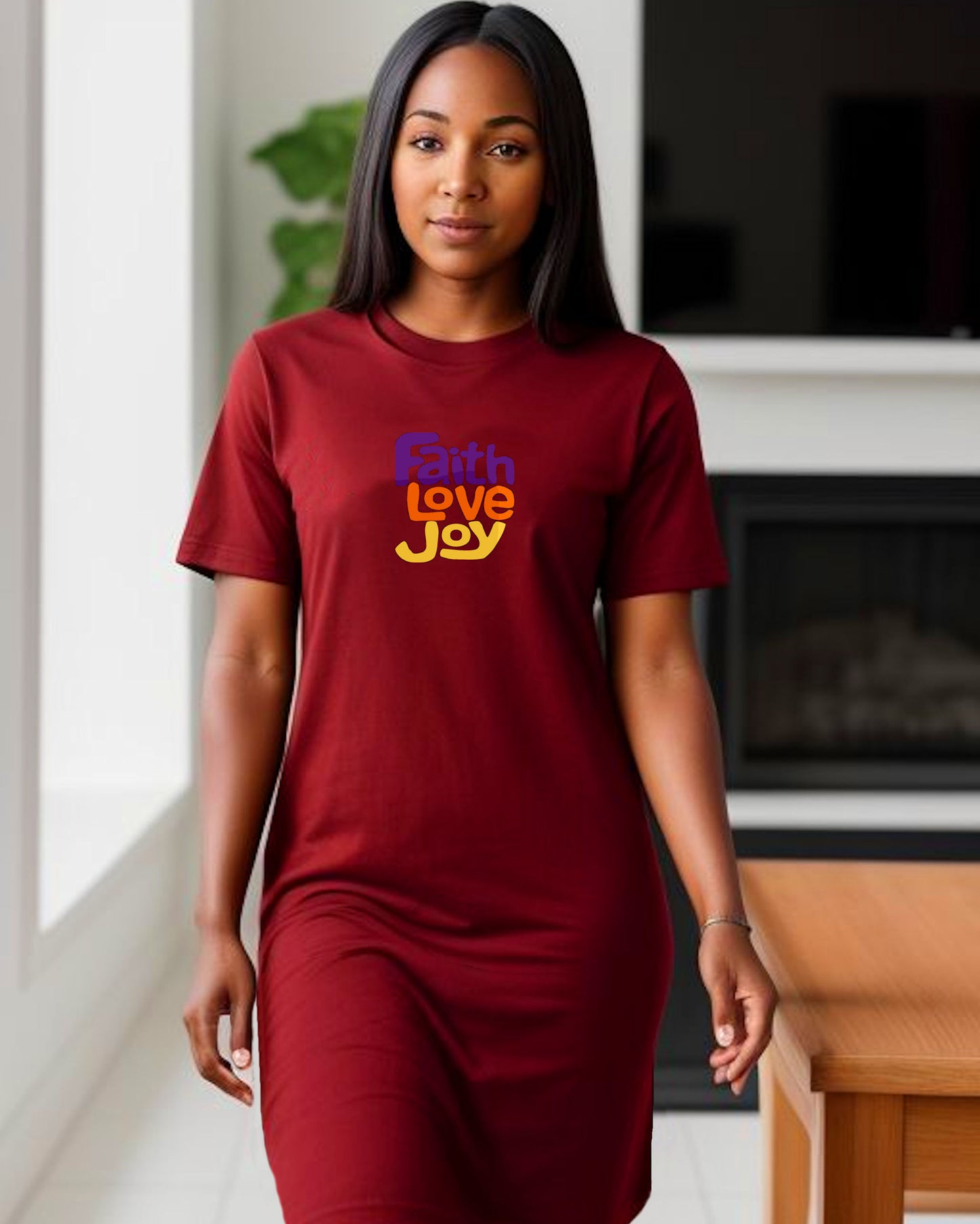 Woman wearing a red t-shirt dress with 'Faith Love Joy' text in a dining room.