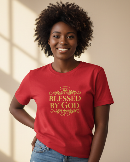Woman wearing a red t-shirt with a gold "Blessed By God" text logo against a beige wall background